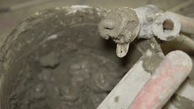 Shotcrete application. Close-up of worker's hand operating pneumatic nozzle spraying a layer of shotcrete onto polystyrene panels attached to wire mesh. House with polystyrene insulation. - Powered by Shutterstock - Get 15% off with code: PIKWIZARD15
