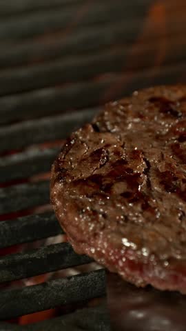 Slow Motion of Minced Beef on a Grill with Roaring Flames . Filmed on High Speed Cinematic Camera at 1000 FPS .