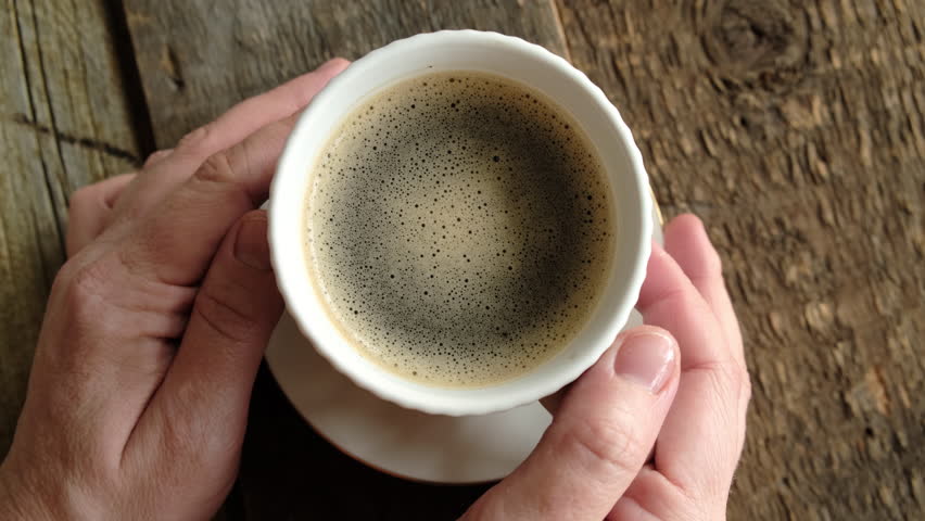 Female hands with a cup of coffee. Woman drinking espresso coffee. POV. Morning routine.