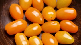 Yellow grape cherry tomatoes in a rustic wooden bowl. Top view. Rotation - Powered by Shutterstock - Get 15% off with code: PIKWIZARD15