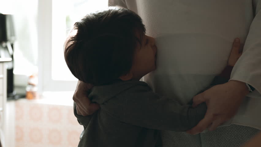 Mother's Embrace in Daily Life - Young Boy Finds Solace in Mom's Arms, A True-to-Life Snapshot of Family Bonding and Comfort
