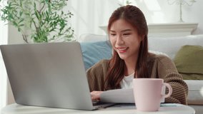 Young asian woman using laptop with happy and satisfaction in living room at home, woman relaxation with notebook computer or working from home, business browsing email, business and freelance. - Powered by Shutterstock - Get 15% off with code: PIKWIZARD15