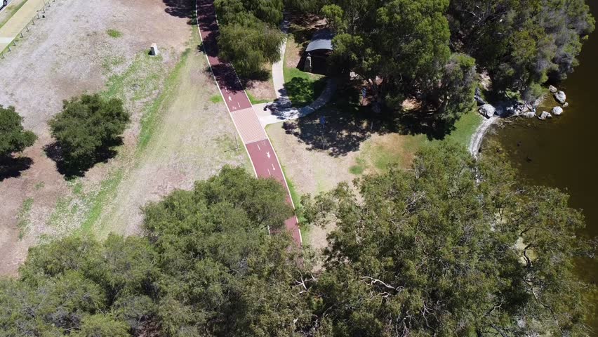 Aerial birds eye view over cyclepath winding near lakeside Joondalup Perth