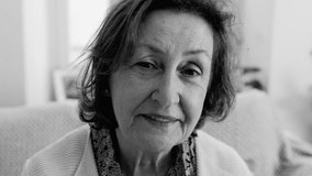 Senior woman smiling, close-up portrait in black and white, natural expression, wrinkles, warmth, elderly lady, happy face, wisdom in eyes, comfortable home setting, intimate moment - Powered by Shutterstock - Get 15% off with code: PIKWIZARD15