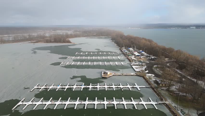 Aerial push in on A snow covered dock at Presque Isle State Park.