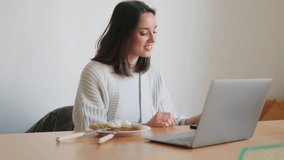 A young woman enjoys a healthy breakfast while working remotely. She eats avocado toast and drinks orange juice while checking her laptop and phone. - Powered by Shutterstock - Get 15% off with code: PIKWIZARD15