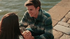 Romantic Couple Shares a Kiss by the River in Seville. A young man gives a flower to his girlfriend and they kiss by the Guadalquivir River. - Powered by Shutterstock - Get 15% off with code: PIKWIZARD15