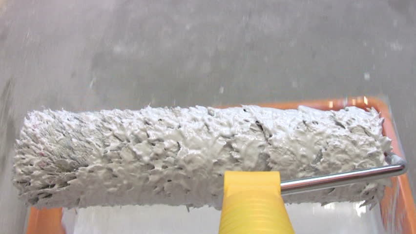 Paint roller in close-up. Gaining gray paint in the bath and paint the wall