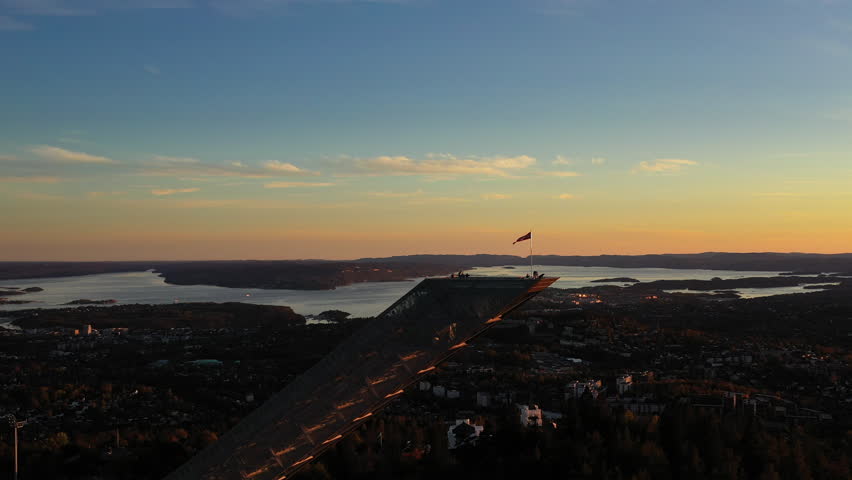 Aerial Drone shot at dusk of tourists on top of world famous Ski jumping hill in Holmenkollen. Holmenkollen in Oslo, Norway.