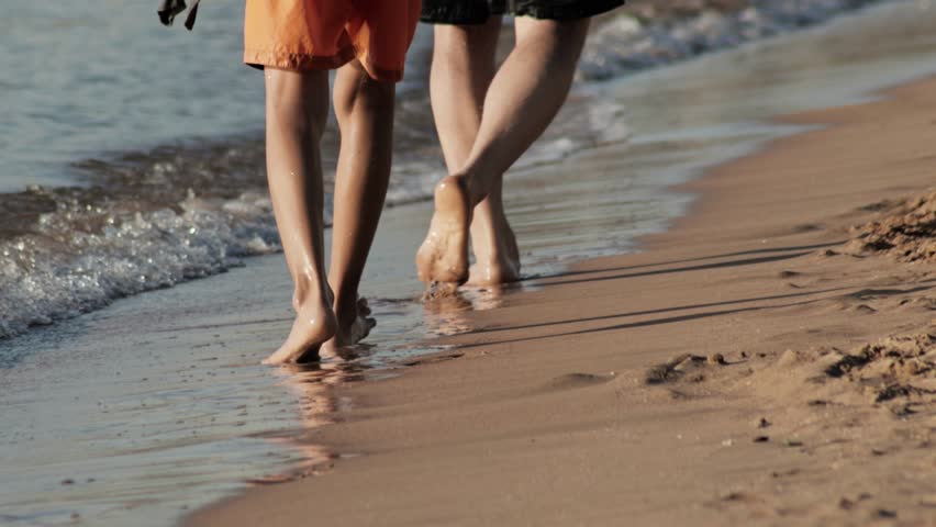 Parents their teenager boy wandered across sunlit coastline barefoot, savoring precious moments of togetherness during getaway. Happy family ambled beside turquoise waters, creating lasting memories