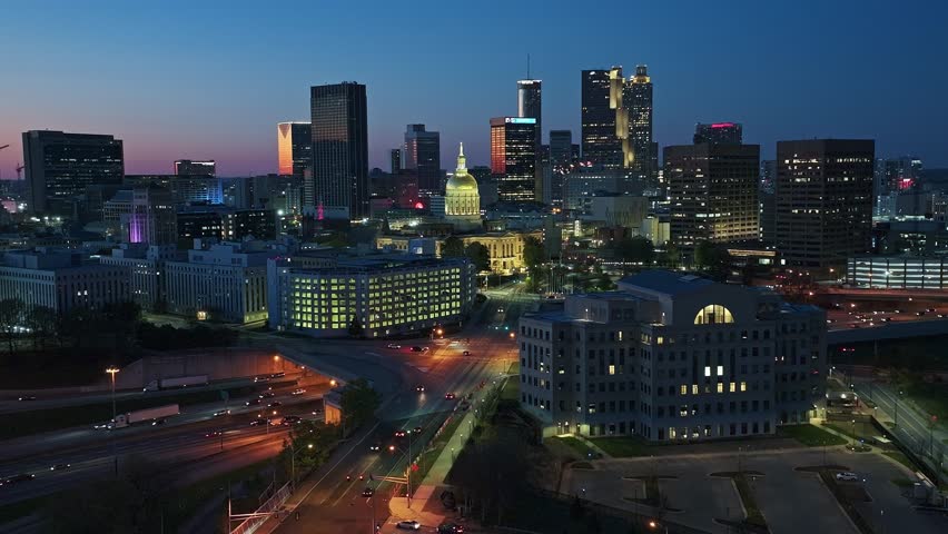 Atlanta Skyline lighting in warm lights at twilight.Aerial Panorama wide shot. Traffic scene on underpass highway and skyscrapers buildings. Sunset time in american city in Georgia, USA.