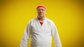 Senior martial arts master bowing in greeting before fight on yellow background - Powered by Shutterstock - Get 15% off with code: PIKWIZARD15