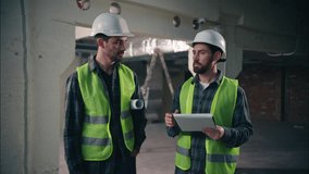 Two joyful smiling Caucasian architects guys colleagues men technicians talking conversation males builders coworking mechanics shake hands handshake teamwork in construction workers partnership plan - Powered by Shutterstock - Get 15% off with code: PIKWIZARD15