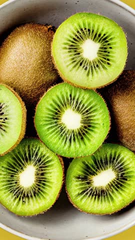 Kiwi in a bowl on yellow background 