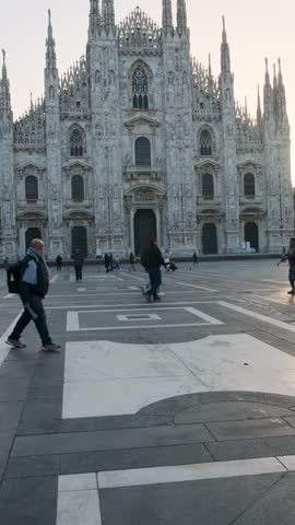 Milan, Italy - October 30, 2024: Milan Cathedral on Cathedral Square with tourists at sunrise, Milan, Lombardy, Italy. Piazza del Duomo with Duomo di Milano with intricate Gothic architecture