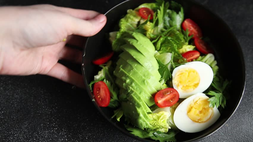 Avocado salad, boiled egg, tomato, green leaf lettuce, vegetable dish fresh delicious gourmet food background on the table rustic food top view copy space keto and paleo diet vegetarian food