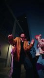 Vertical. Dancing young people breakdancing in street hip hop dancer practicing dance routine performing freestyle moves in city at night. Urban style friends rap music - Powered by Shutterstock - Get 15% off with code: PIKWIZARD15