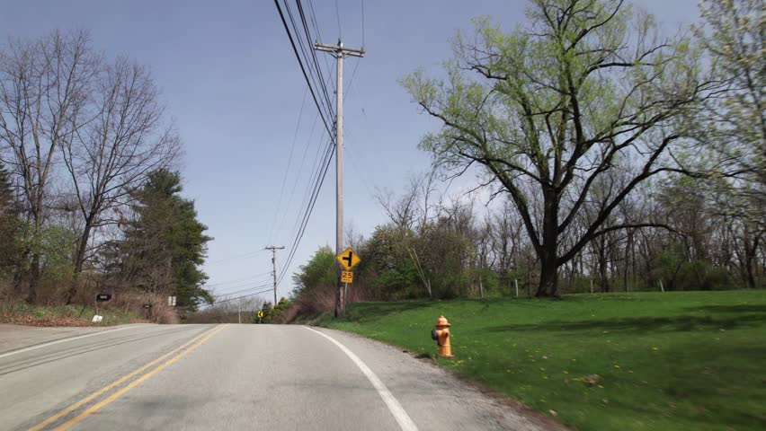 Car driving on road point-of-view POV in greater Pittsburgh, PA area in north hills of roads, infrastructure, hills, lanes, buildings, homes, and businesses close to West Virginia landscape scenary 