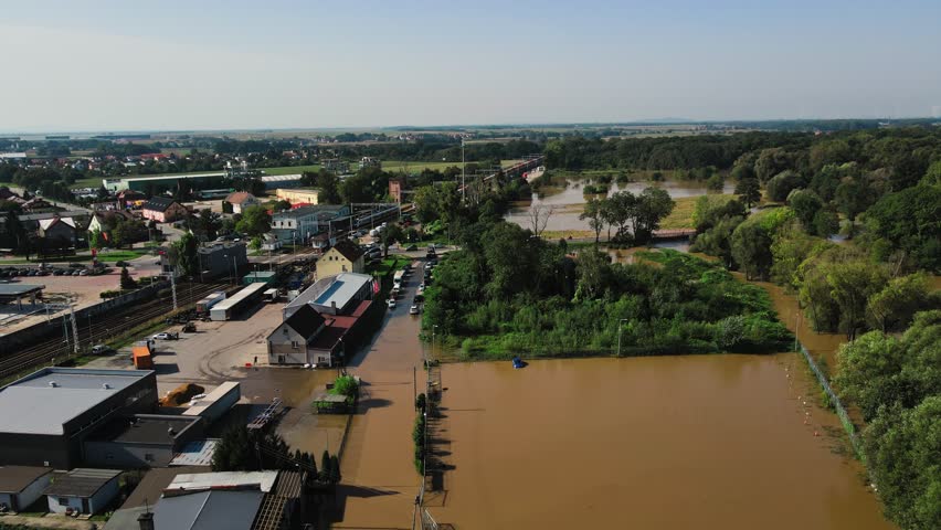 Aerial view of flooded railway tracks and buildings in a suburban area. Industrial zone with floodwater after heavy rain. Concept of natural disaster, climate impact and emergency