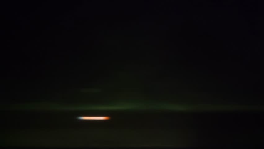 Side view from a vehicle passing through a dark tunnel with motion blur suggesting speed, leading to a bright exit