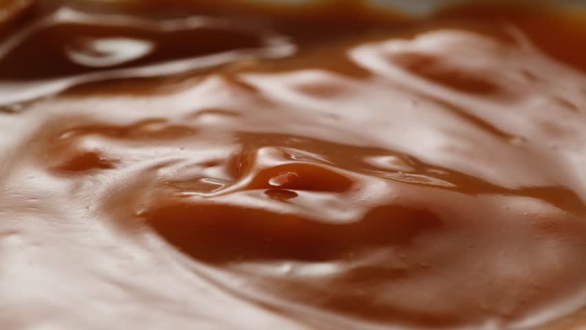 Pancakes with condensed milk on a plate in a restaurant, cutlery, knife and fork cut delicious pancakes poured with condensed milk.