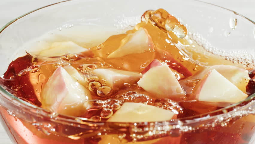 Apple juice or cider is pouring from a bottle into a glass. Fresh drink with apples and pear on an old kitchen table. 