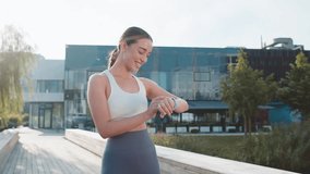 Athletic runner woman looks at smartwatch device fitness bracelet checking time, heart rate, pulse, SPO2 on smartwatch while jogging. Young girl working out cardio outside in sunny urban city park. - Powered by Shutterstock - Get 15% off with code: PIKWIZARD15