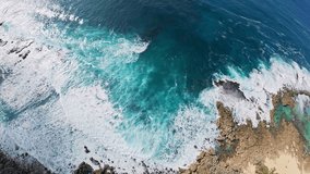 Dynamic aerial view of turquoise ocean waves crashing on rocky outcrops, bordered by dense tropical vegetation along the Hawaiian coastline. - Powered by Shutterstock - Get 15% off with code: PIKWIZARD15