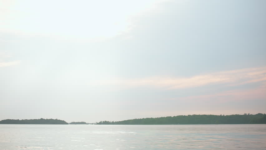 Handheld shot of the St. Lawrence River from Wellesley Island State Park, Fineview, NY. Soft sky tones meet shimmering waters for a tranquil view.