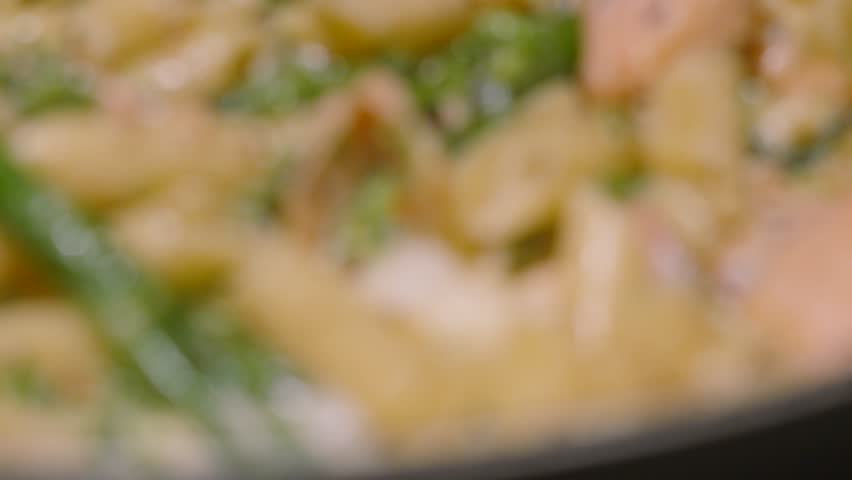 Focus Pull to Bubbling Creamy Delicious Salmon and Broccoli Penne Italian Pasta on Stove with Cracked Black Pepper. Cooking Kitchen Seafood Healthy Eating Footage 4K.