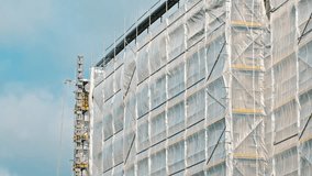  Industrial Scaffolding Secured with Safety Net Tarp at Multi Storey Residetial Building Construction Site - Powered by Shutterstock - Get 15% off with code: PIKWIZARD15