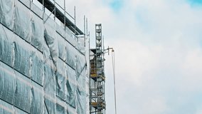  Industrial Scaffolding Secured with Safety Net Tarp at Multi Storey Residetial Building Construction Site - Powered by Shutterstock - Get 15% off with code: PIKWIZARD15