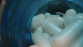 White Capsules Spilling from Open Blue Lids with Supplement Bottles in the Background, Illuminated in a Detailed Dolly slider, close up. - Powered by Shutterstock - Get 15% off with code: PIKWIZARD15