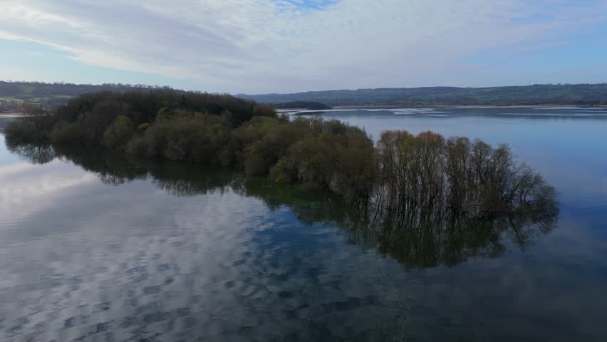 Aerial footage of Chew Valley Lake, highlighting its sky-reflecting waters and surrounding green countryside.