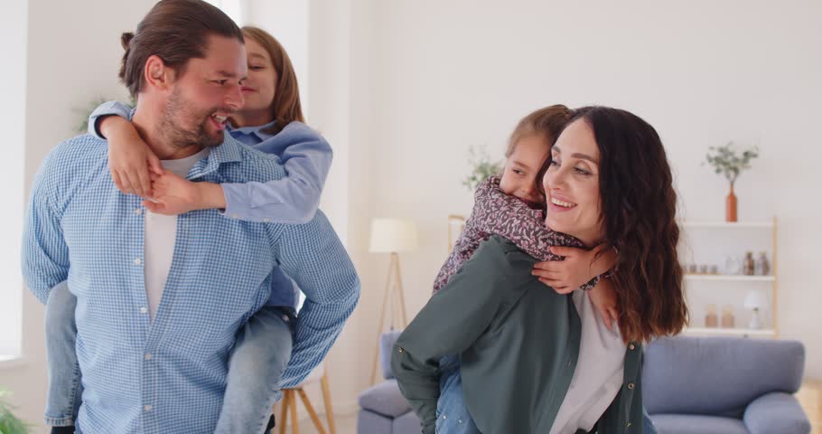 Portrait of young family, beautiful mother, father carefree daughter, son piggyback ride for funny amuse at home, enjoying moments of bonding and fun between loving parents and children on weekend 