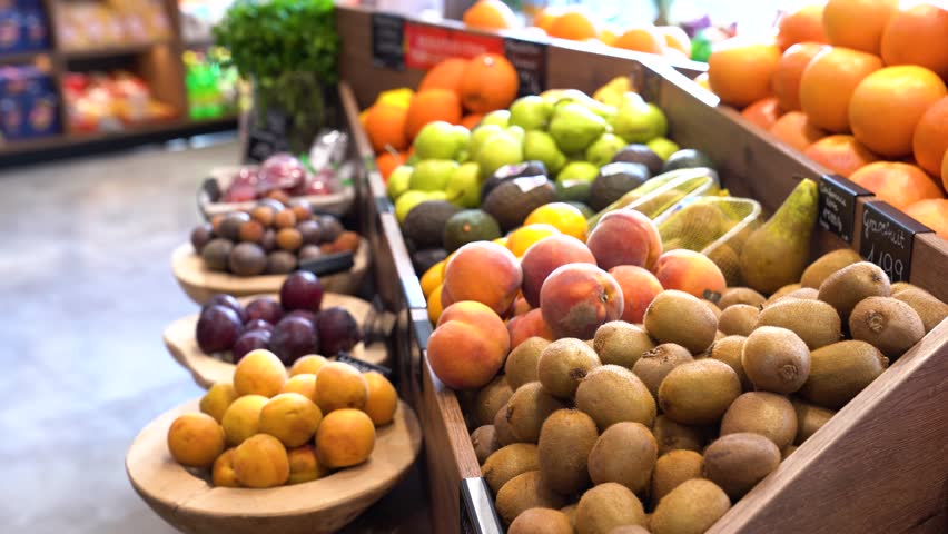 Kiwi, Peach, Pomegranate And Orange On The Fruit Section Of Grocery. - closeup shot