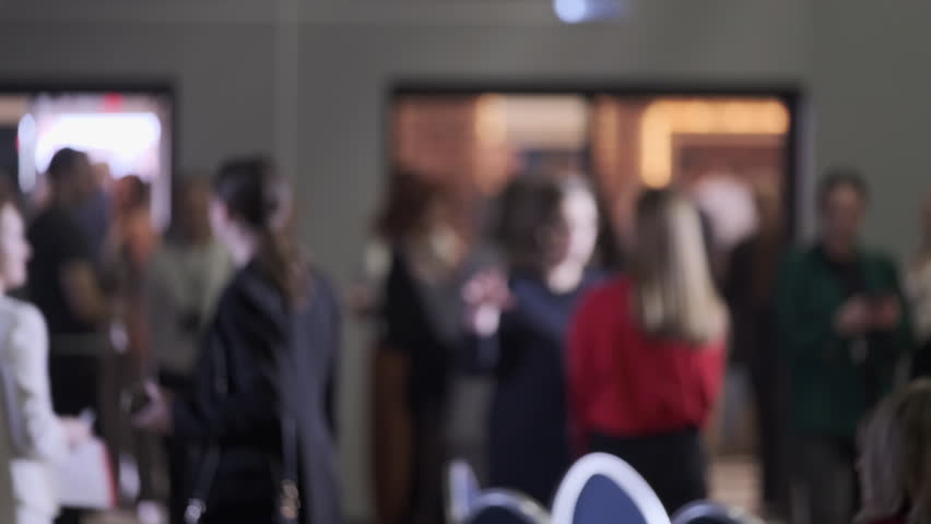 Blurred view of people attending a business conference or networking gathering event indoors