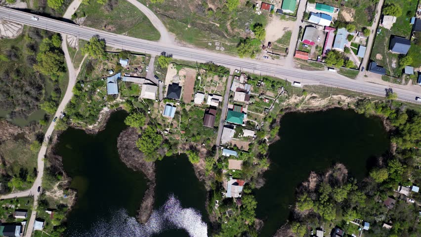 A small pond in the countryside. Old apartment buildings on the outskirts.