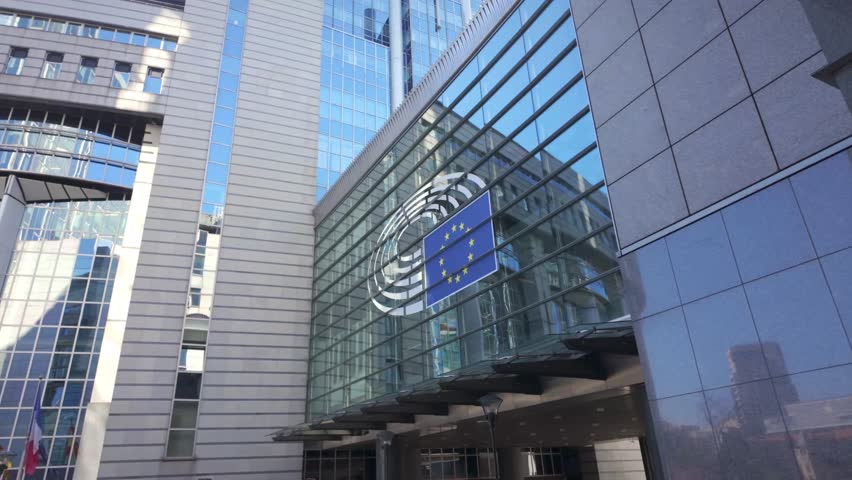 Walking toward EU Parliament building with European flag in view