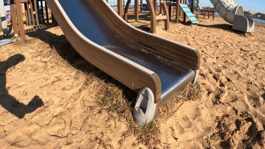 A playful view of a slide on a kids playground, filmed to go upwards, inviting joy and excitement.