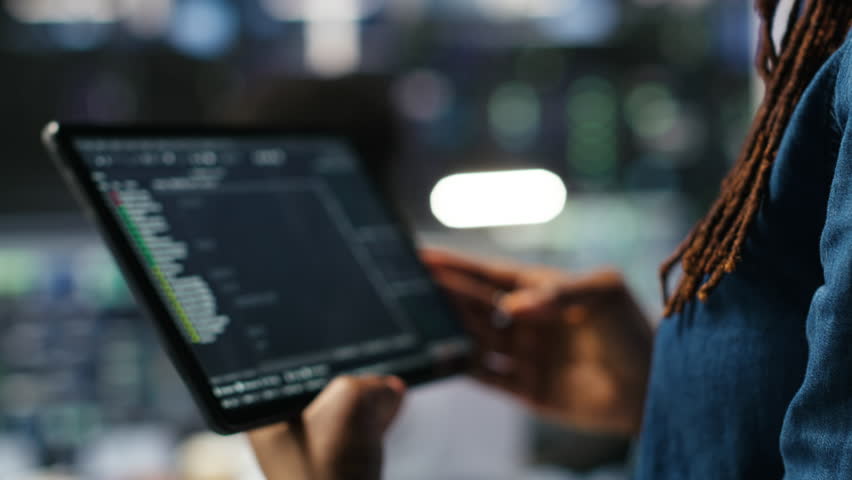 Close up of server room programmer checking coding on tablet enhancing operational efficiency and reducing downtime. Developer verifying programming language script used to update gear, camera B