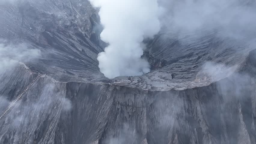 aerial view flying to mount Bromo active volcano above sea of clouds, Java, Indonesia