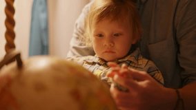 The child, with soft blonde hair, stares intently at a globe in this close-up shot. Their serious expression reflects a moment of pure curiosity and focused discovery. - Powered by Shutterstock - Get 15% off with code: PIKWIZARD15