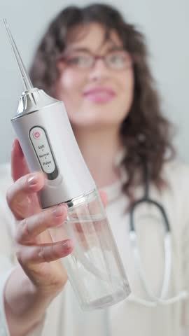 Dentist woman reveals all the secrets of a dental irrigator, showing how to easily clean the mouth at home.