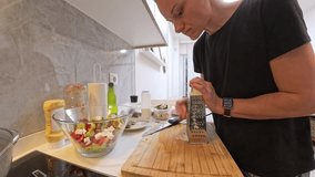 Woman in Black Shirt Grating Cheese on Wooden Cutting Board with Large Glass Salad Bowl and Various Ingredients in Kitchen. Meal Preparation Concept - Powered by Shutterstock - Get 15% off with code: PIKWIZARD15