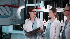 scientific research in medicine, young female doctors in medical gowns analyze DNA model during genetic research presentation in clinical setting in laboratory - Powered by Shutterstock - Get 15% off with code: PIKWIZARD15