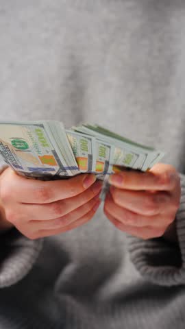 Woman counting US Dollar bills, close-up