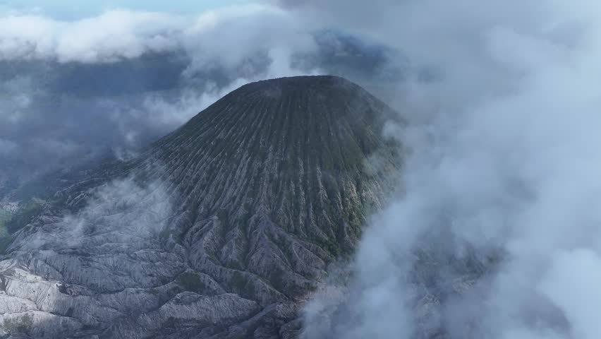 aerial view flying to mount Bromo active volcano above sea of clouds, Java, Indonesia