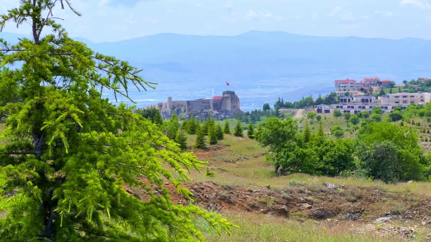 Harput fortress with the Turkish flag, in the spring in Eastern Anatolia, Elazig, Turkey. Harput Castle or Harberd, also known as Sut Kalesi. Ancient city. 4К
