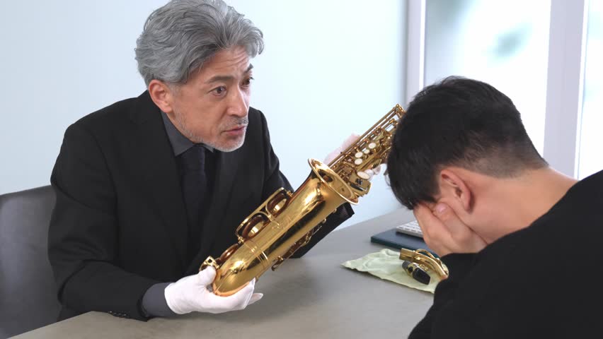 Japanese man examining a saxophone